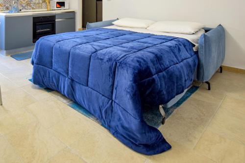 a blue comforter on a bed in a room at Rosa azzurra in Casamassima