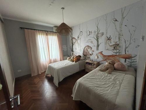 ein Schlafzimmer mit zwei Betten mit ausgestopften Tieren in der Unterkunft Praderas de San Lorenzo in El Durazno