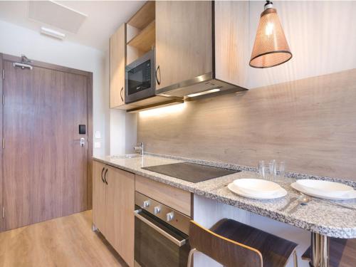 a kitchen with a counter with a sink and a stove at Livensa Living Studios Bilbao in Bilbao