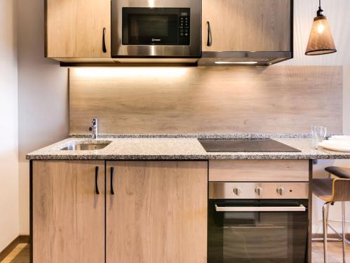 a kitchen with a sink and a microwave at Livensa Living Studios Bilbao in Bilbao