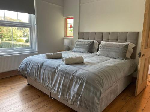 a large bed in a bedroom with a large window at Trosnant, Ewyas Harold in Hereford