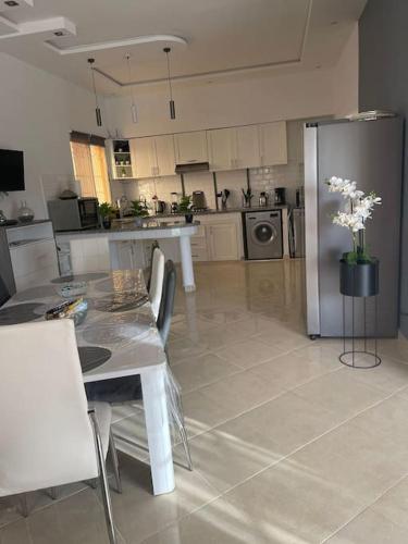 a large kitchen with a table and a refrigerator at Villa Privée 1 Marrakech Piscine Chauffée En Option Sans Vis-à-vis pour famille et couple marié uniquement in Marrakech