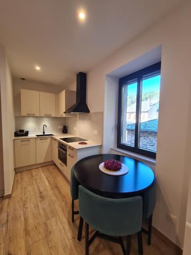 une cuisine avec une table et des chaises dans une pièce dans l'établissement Apartament centre de Formiguères, à Formiguères