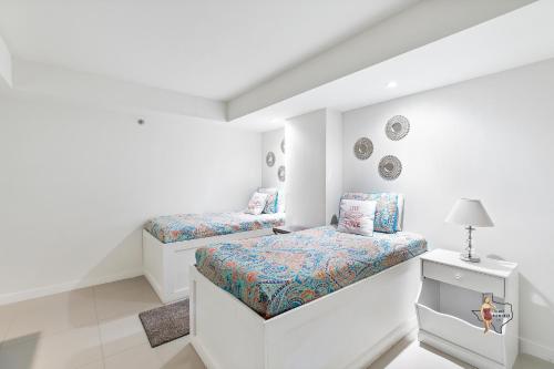 a white room with two beds and a lamp at Bahia Mar-Solare Tower, Beachfront Resort with Two Pools in South Padre Island