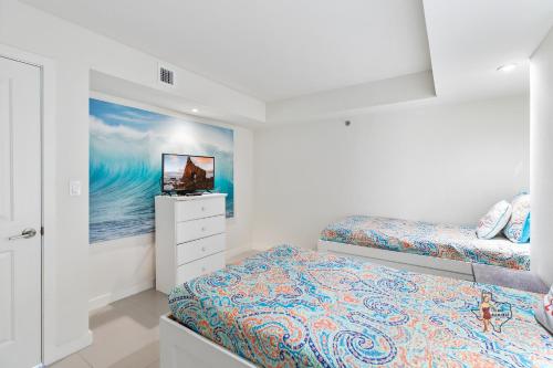 a bedroom with two beds and a tv in it at Bahia Mar-Solare Tower, Beachfront Resort with Two Pools in South Padre Island
