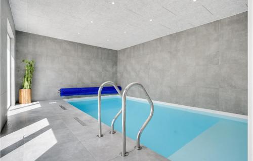 una piscina coperta con acqua blu in una stanza di Awesome Home In Ebeltoft With Sauna a Ebeltoft