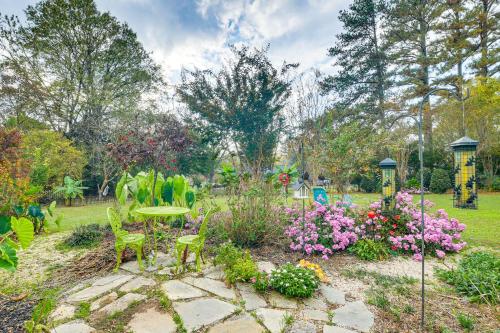 a garden with a table and chairs and flowers at 4 Mi to Falls Lake Dog-Friendly Wake Forest Home in Wake Forest