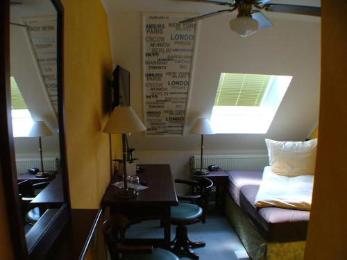 a hotel room with a bed and a desk and a mirror at Hotel garni Pension Zur Lutherstadt in Lutherstadt Eisleben