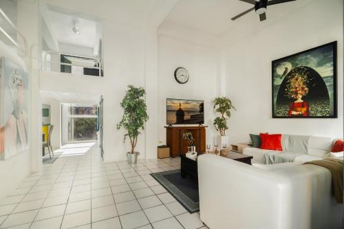 a white living room with a couch and a clock at Spanish Old San Juan Penthouse in San Juan