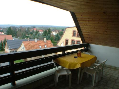 a yellow table and chairs on a balcony with a window at Hotel garni Pension Zur Lutherstadt in Lutherstadt Eisleben