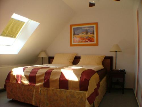 Hotel garni Pension Zur Lutherstadt في لوثرستادت ايسليبن: غرفة نوم مع سرير في العلية مع نافذة
