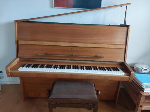 a wooden piano with a stool in a room at Holiday Home Matthäus am Corfutrail, Ferienoase im Olivenhain 3 km zum Meer in Giannádes