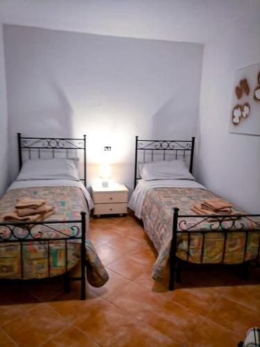 a bedroom with two beds and a lamp on a table at Casa Silvia Balsorano in Balsorano Vecchio