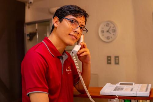 a young man talking on a phone while holding a telephone at Hotel Estrella in Managua