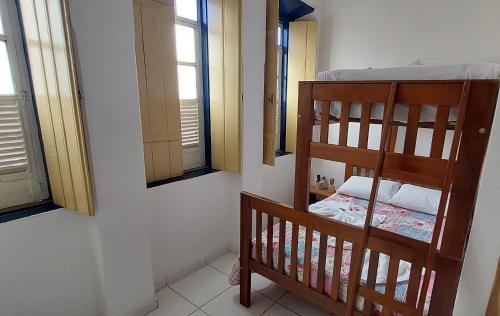a bedroom with a bunk bed and two windows at Pousada Athena in Palmeiras