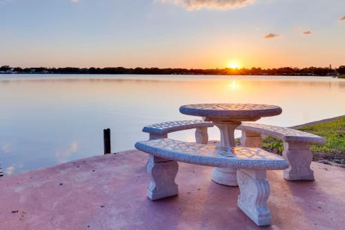 a picnic table and benches in front of a lake at 16 Mi to Manatee Viewing! Spacious Tampa Retreat in Tampa