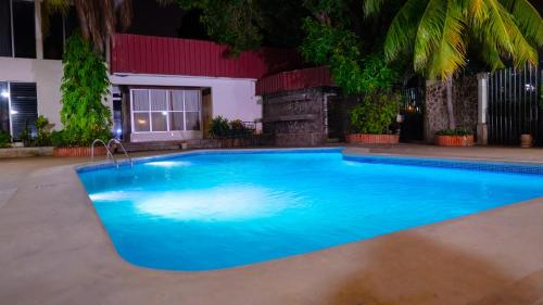 a large blue swimming pool at night at Hotel Estrella in Managua