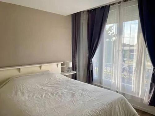 une chambre avec un lit et une grande fenêtre dans l'établissement Le grand COSY - Gare SNCF, à Châlons-en-Champagne