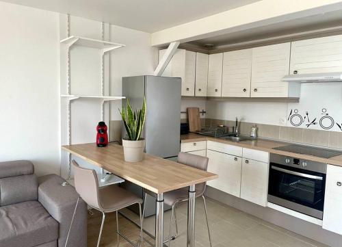 une cuisine avec une table en bois et un canapé dans l'établissement Le grand COSY - Gare SNCF, à Châlons-en-Champagne