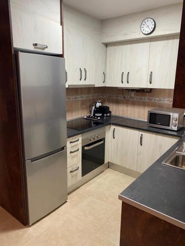 a kitchen with a refrigerator and a microwave at Apartamento Pilarín in Alcañiz