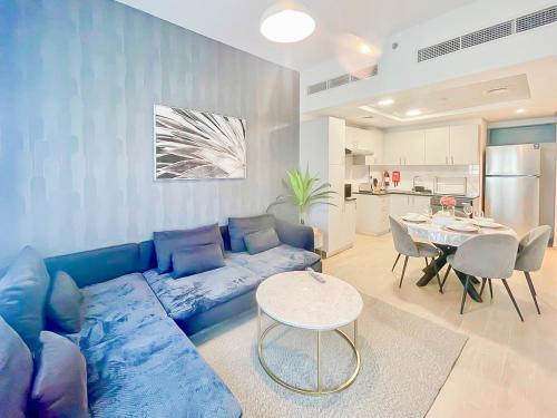 a living room with a blue couch and a table at Luxury 2 Bedroom in the Nook 1 next to Metro Energy in Dubai