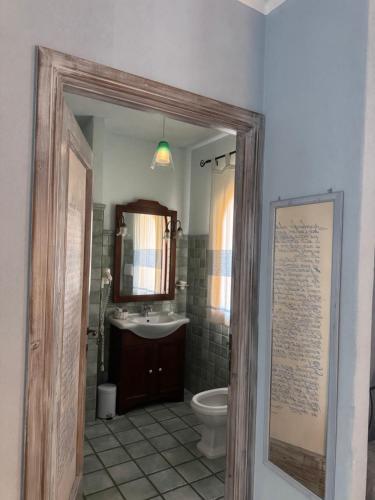 a bathroom with a sink and a toilet and a mirror at Villa Madau in Pula