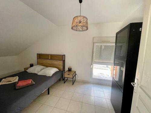 - une chambre avec un lit, une fenêtre et une lampe dans l'établissement COSY 2 couchages - secteur SNCF - Parking, à Châlons-en-Champagne