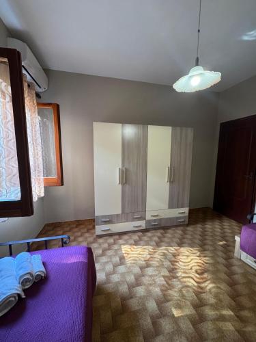 a room with a purple bed and a cabinet at Casa Archi in Cefalù