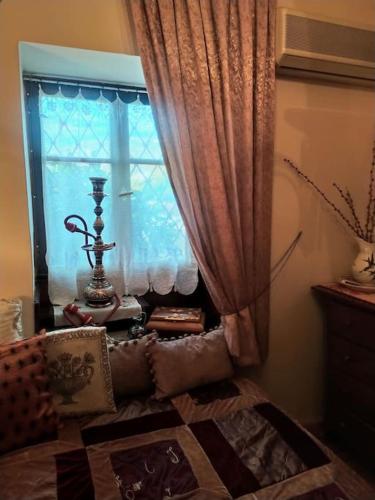 a room with a window with curtains and a couch at Traditional house at Pelion seaside in Agria