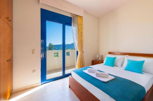 una camera da letto con un letto grande con una grande finestra di Villa Clive by Villa Plus a Líndos