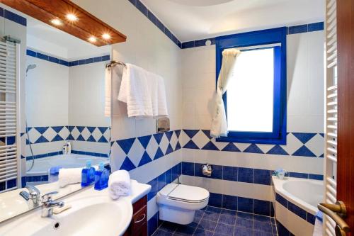 un bagno blu e bianco con un water e un lavandino di Villa Clive by Villa Plus a Líndos