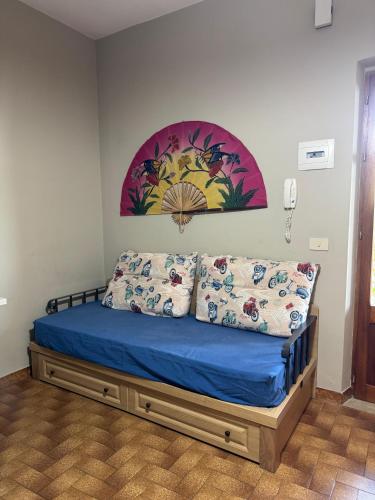 a bed in a room with a painting on the wall at Casa Archi in Cefalù