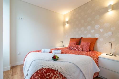 a bedroom with a large bed with orange pillows at Host Wise - Large Colourful Flats - Ace Location in Vila Nova de Gaia