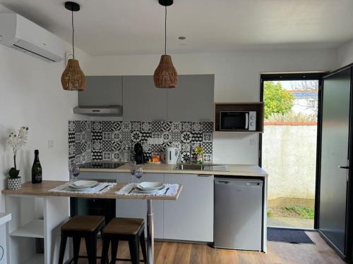 une cuisine avec un comptoir et une table avec des tabourets dans l'établissement Chez la morena proche de La Rochelle, à Lagord