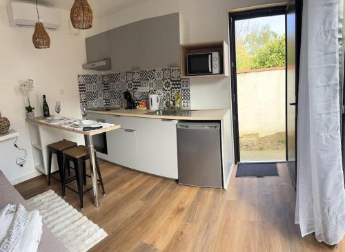 a kitchen with a counter and a table in a room at Chez la morena proche de La Rochelle in Lagord