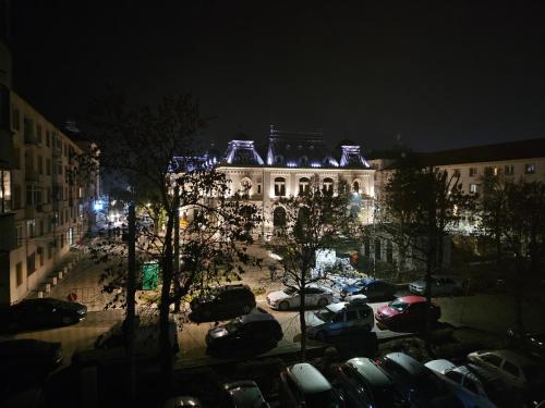 ein Gebäude mit nachts auf einem Parkplatz geparkt in der Unterkunft City Hall Apartament in Craiova