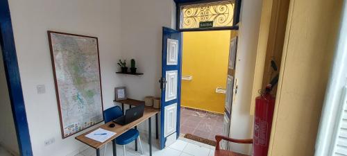 a classroom with a desk and a yellow door at Pousada Athena in Palmeiras