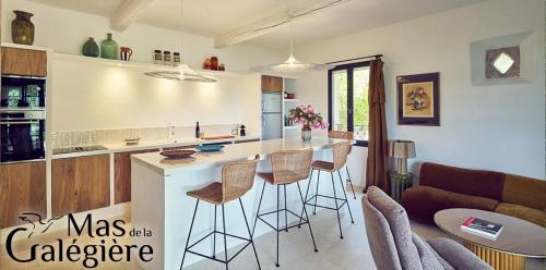 une cuisine avec un comptoir et des tabourets dans une pièce dans l'établissement Mas de la Galégière - Les Maisons, à Arles