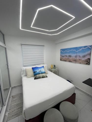 sypialnia z dużym białym łóżkiem i białym sufitem w obiekcie Tiny Home-El Pueblito w mieście Puerto Plata