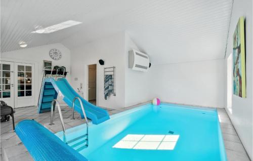 una piscina cubierta con un tobogán azul en Nice Home In Ulfborg With Sauna, en Ulfborg