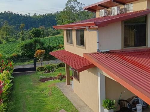 a house with a red roof and a yard at Arenal Dreams House in Fortuna