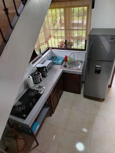 a kitchen with a stove and a sink and a refrigerator at Arenal Dreams House in Fortuna