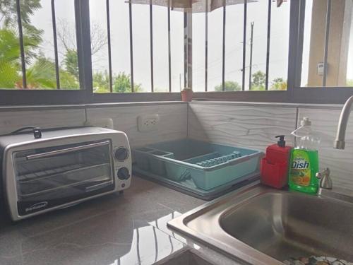 a toaster oven sitting on a counter next to a sink at Arenal Dreams House in Fortuna