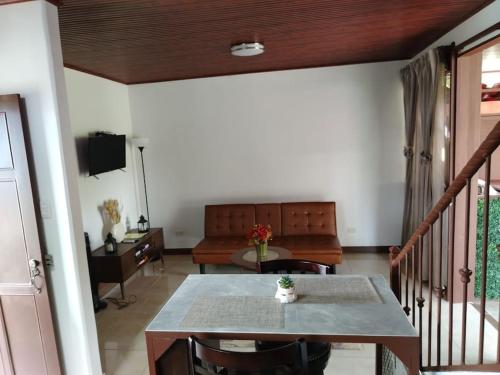 a living room with a table and a couch at Arenal Dreams House in Fortuna