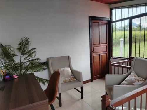 a living room with two chairs and a table at Arenal Dreams House in Fortuna