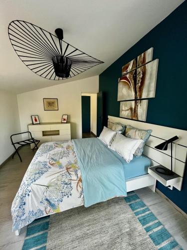 a bedroom with a large bed with a blue wall at Chambre indépendante au calme, petit-déjeuner inclus in Arthès