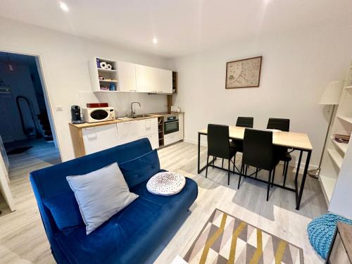 un salon avec un canapé bleu et une table dans l'établissement Gîte à la ferme, T2 Weppes, à Pérenchies