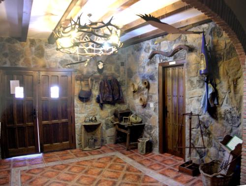 a room with a stone wall and a chandelier at Casa Rural Peña Falcón in Torrejón el Rubio