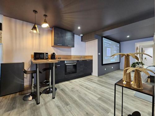 une cuisine avec une table et un comptoir dans l'établissement Balnéo et Cinéma Le Saona, à Bourg-en-Bresse