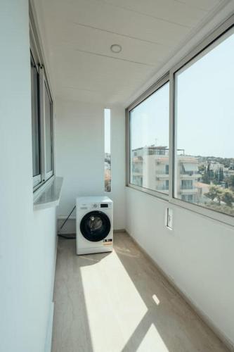 a white room with a window and a microwave at Grand Sea View Apartment 3' from Kavouri Beach in Athens